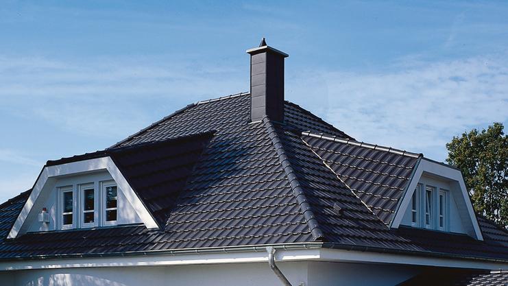 Ein modernes, einheitlich weißes Einfamilienhaus mit Satteldach, Vorgarten und gepflasterter Auffahrt.